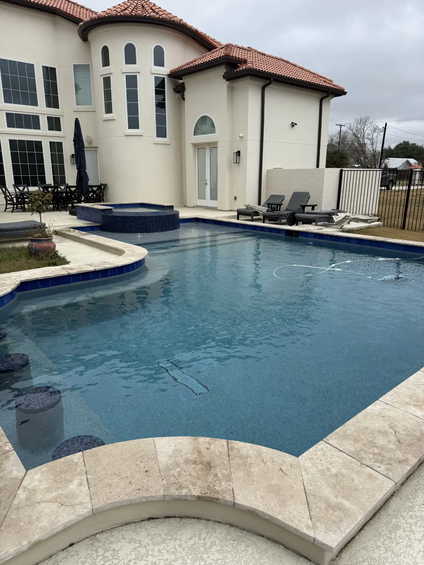 Backyard pool and spa with stone coping